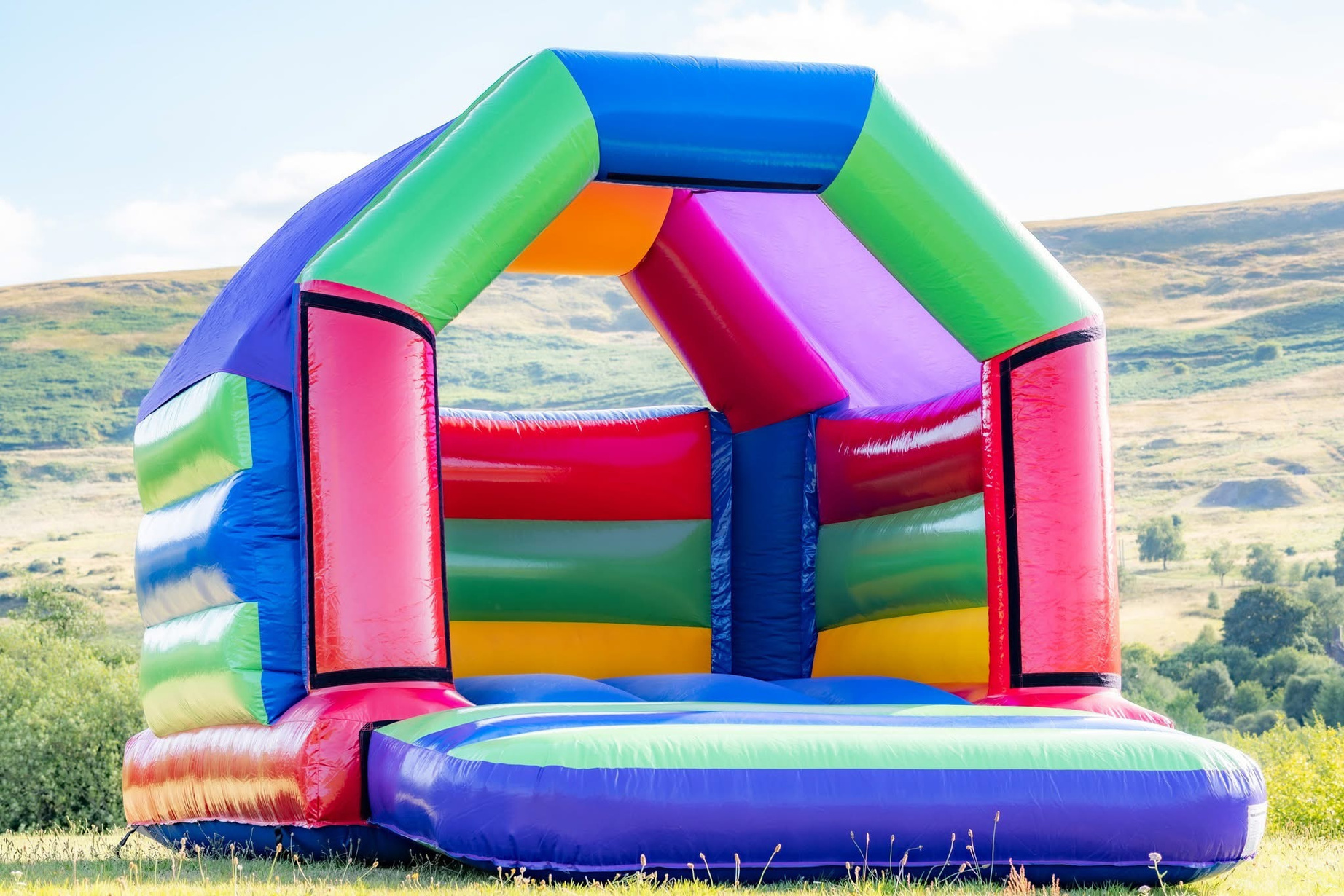 Bright multicolour 11ft by 15ft bouncy castle available for hire in Torfaen and South Wales